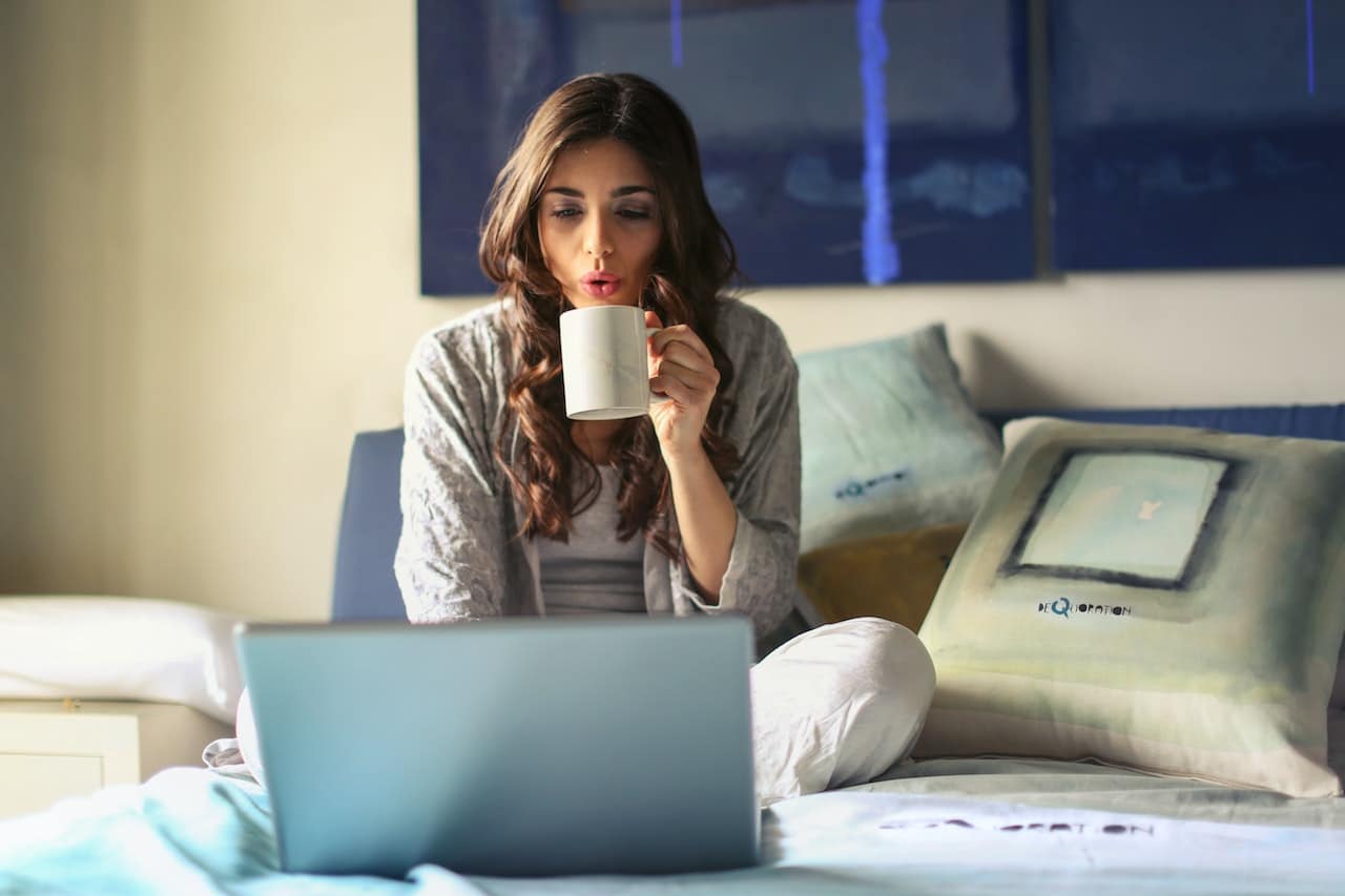 woman using laptop on the bed